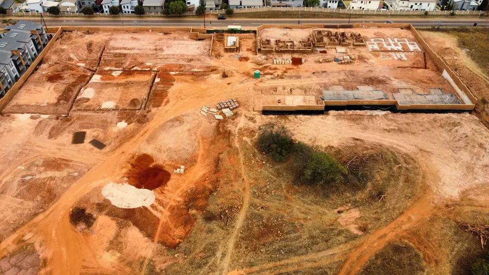 Wide aerial construction progress view across iQ Bronberg