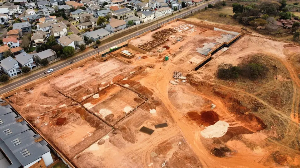 Wide drone view showing iQ Bronberg construction within the surrounding residential area