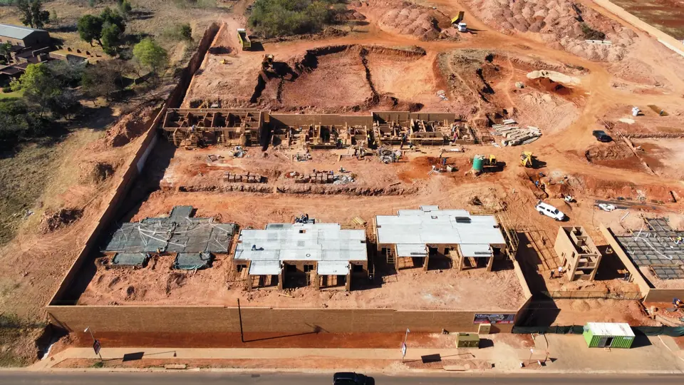 Aerial view showing rising walls and completed concrete slabs at iQ Bronberg