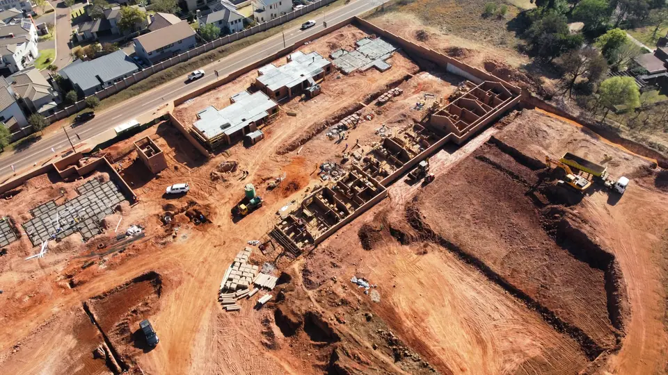Oblique aerial view of masonry rising across Phase 1 at iQ Bronberg