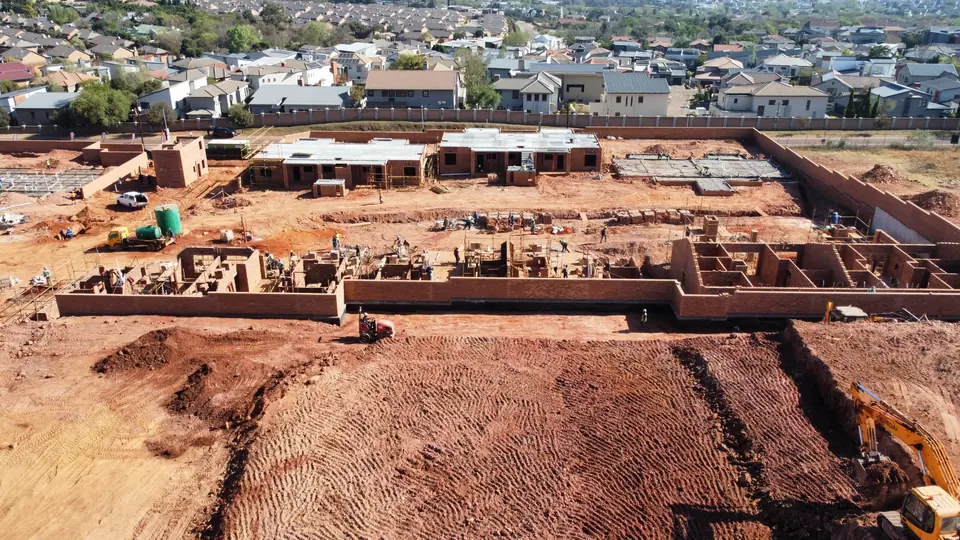 Straight-on aerial view showing construction progress across the front Phase 1 blocks
